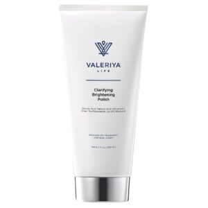 The image shows a tube of "Clarifying Brightening Polish" from the brand Valeriya Life. The tube has a sleek, white design with a simple label featuring the product name and logo in clean, bold text. The cap of the tube is silver, adding a touch of elegance. The product is placed on a neutral, light-colored background, emphasizing its minimalist and professional appearance.