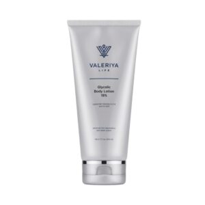 The image shows a tube of "Glycolic Body Lotion 15%" from brand Valeriya Life with a sleek, silver design. The background is neutral and simple, highlighting the product's clean, minimalistic packaging. The label includes product ingredients and is easy to read.