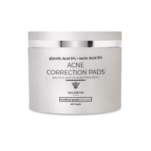 The image shows a jar of "Acne Correction Pads" from the brand Valeriya Life, featuring a sleek, silver container with a silver lid. The product label displays the name, key ingredients and benefits in a modern, clean font. The product is placed on a neutral background, emphasizing its clean and modern packaging. The container is designed for easy access to the pads, which are pre-soaked in acne-fighting ingredients intended to target and treat acne with its potent formula.
